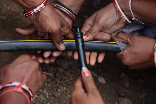 Multiple hands holding a Spowdi system irrigation tube